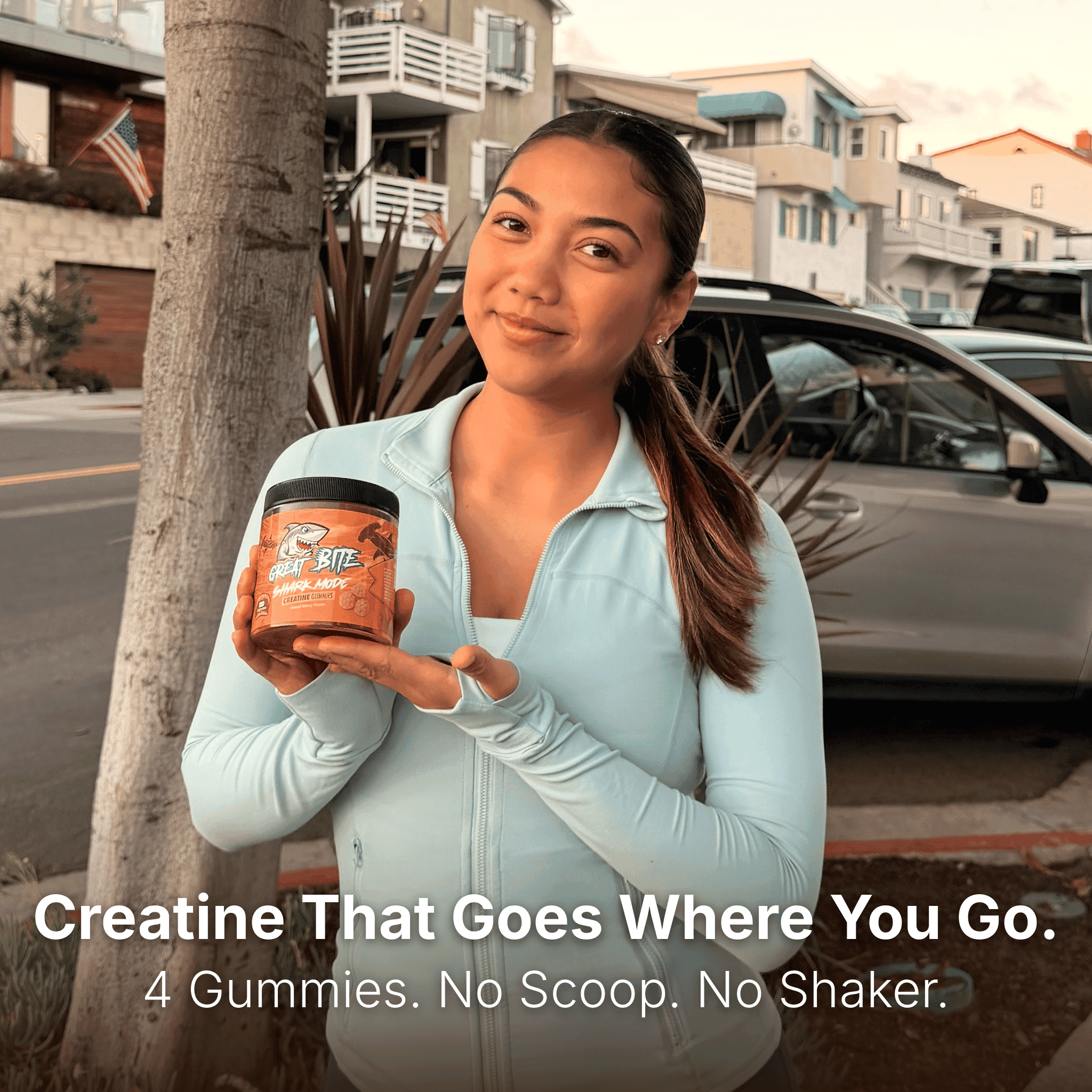 A woman holding a bottle of Shark Mode Creatine outdoors